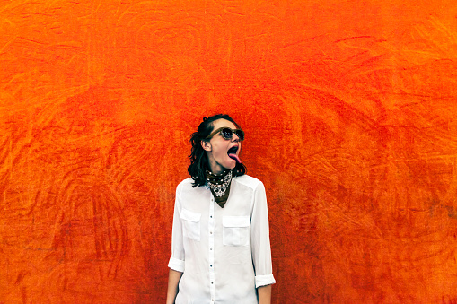 Woman making faces on orange and red background